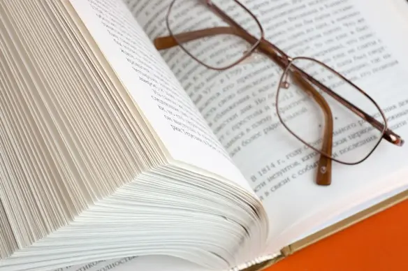 Un libro abierto y unos lentes