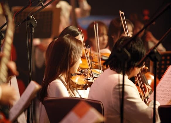 Unas personas tocando varios instrumentos vistas de costado