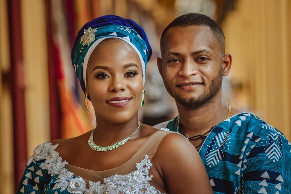 Una pareja de hombre y mujer afrodescendientes vestidos con ropa afrocaribeña
