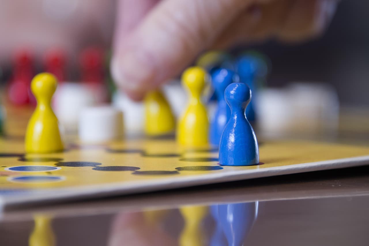 Parte de un juego de mesa con un tablero y figuras de colores
