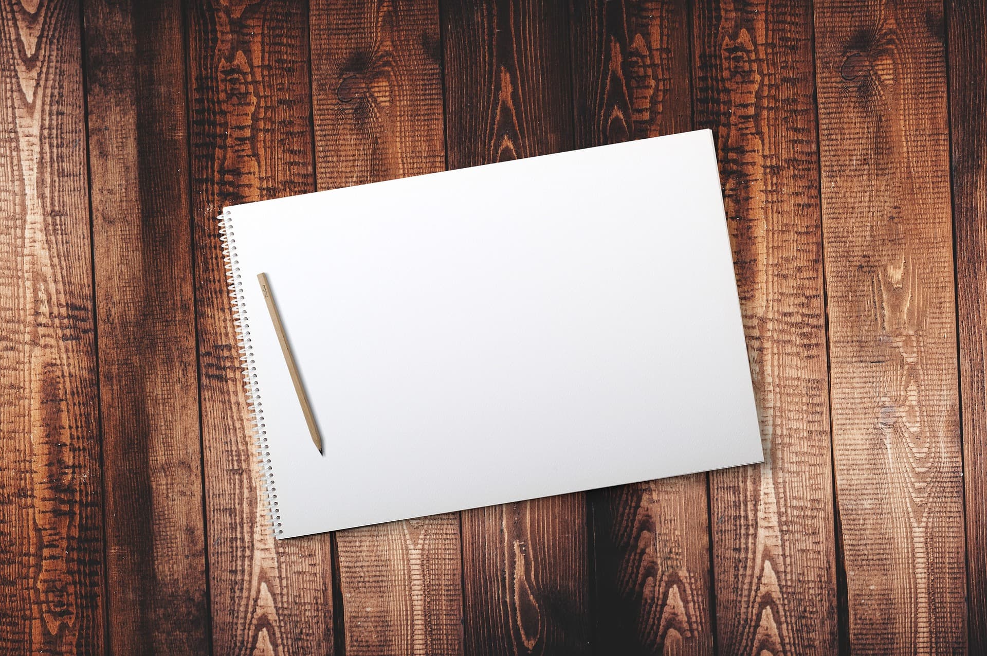 Un cuaderno de bocetos en blanco y un lápiz de grafito