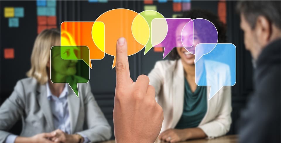 Varias personas reunidas conversando de fondo y unos cuadros de diálogo de diálogo en primer plano