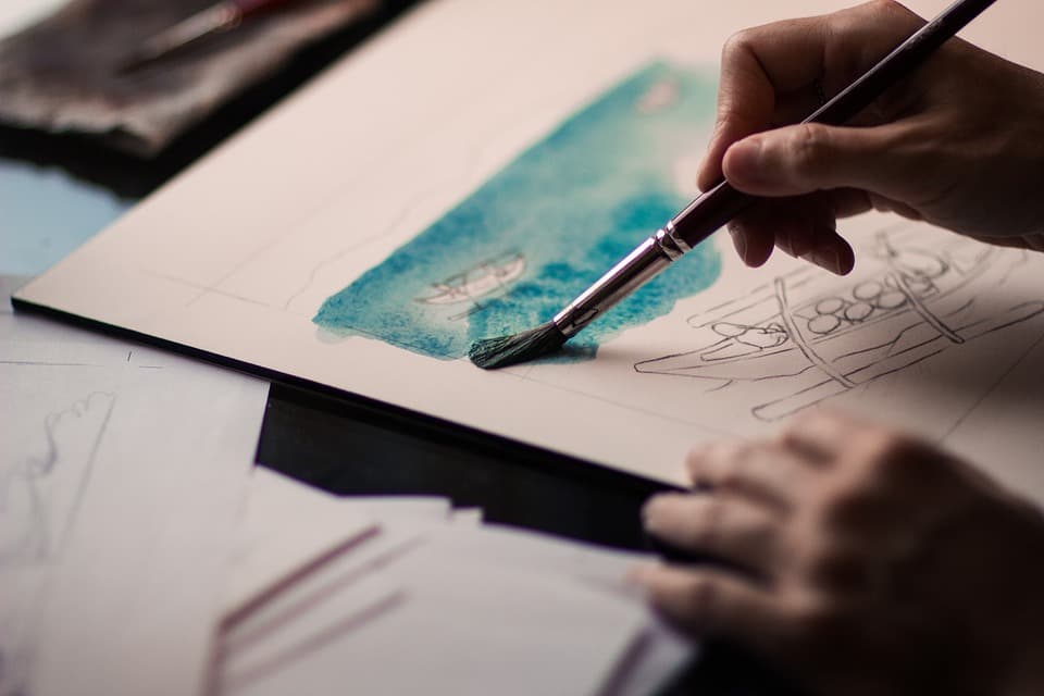 Un persona pintando sobre papel con acuarela