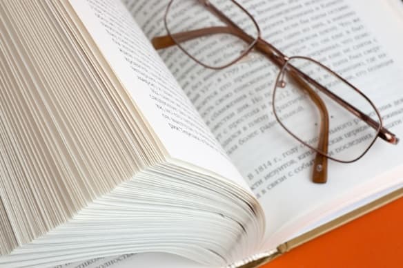 Un libro abierto con unos lentes